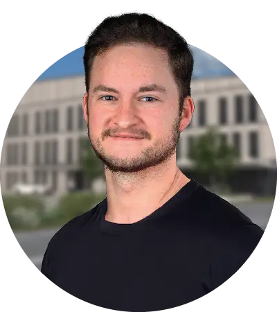 Das Bild zeigt den Inhaber des nineseven Fitnessstudios im Medical Center Windmühle in Unterpleichfeld. Daniel Varga trägt ein schwarzes T-Shirt und lächelt in die Kamera. Er ist in einem runden Kreis platziert.